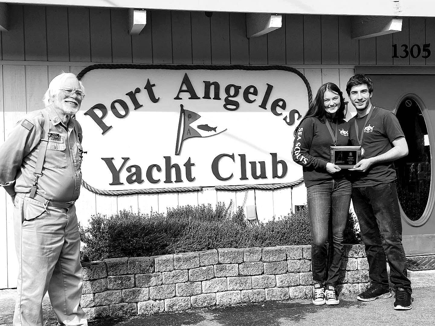 Submitted photo
Sailors Ella Schultz, middle, and Ozzy Minard earned a first-place finish in the first Kelly Cup Regatta hosted by the Sea Scout Ship Marvin Shields and the Port Angeles Yacht Club, represented by Doug Mecham.
