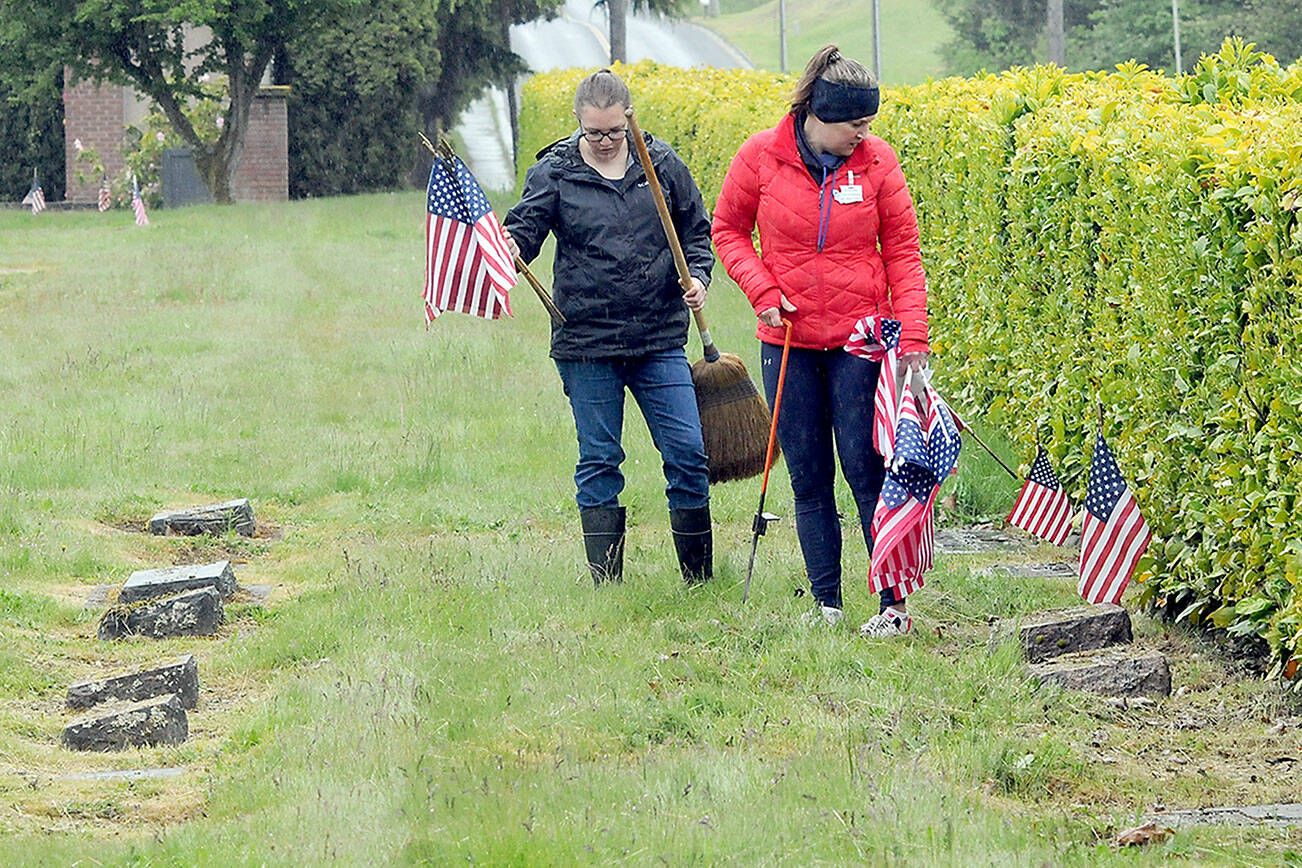 Monica Reynolds, a prospective member of the Daughters of the American Revolution, left, and Lindsey Christianson, a member of the organization’s Port Angeles-based Michael Trebert Chapter, locate graves of veterans for adornment with American flags on Saturday for Monday’s Memorial Day ceremony at 9:30 a.m. at Mount Angeles Memorial Park, 45 Monroe Road in Port Angeles. (Keith Thorpe/Peninsula Daily News)