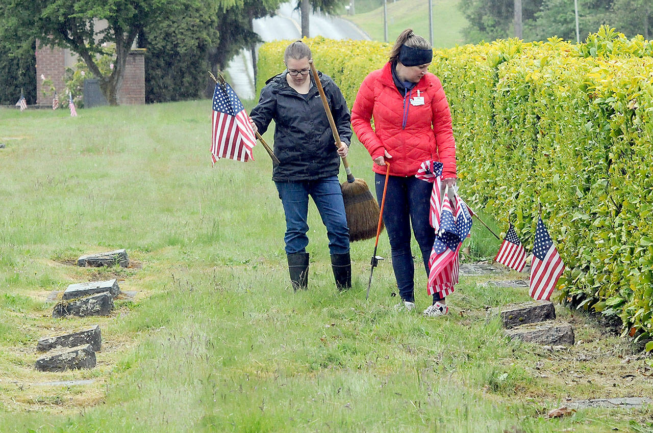Monica Reynolds, a prospective member of the Daughters of the American Revolution, left, and Lindsey Christianson, a member of the organization’s Port Angeles-based Michael Trebert Chapter, locate graves of veterans for adornment with American flags on Saturday for Monday’s Memorial Day ceremony at 9:30 a.m. at Mount Angeles Memorial Park, 45 Monroe Road in Port Angeles. (Keith Thorpe/Peninsula Daily News)