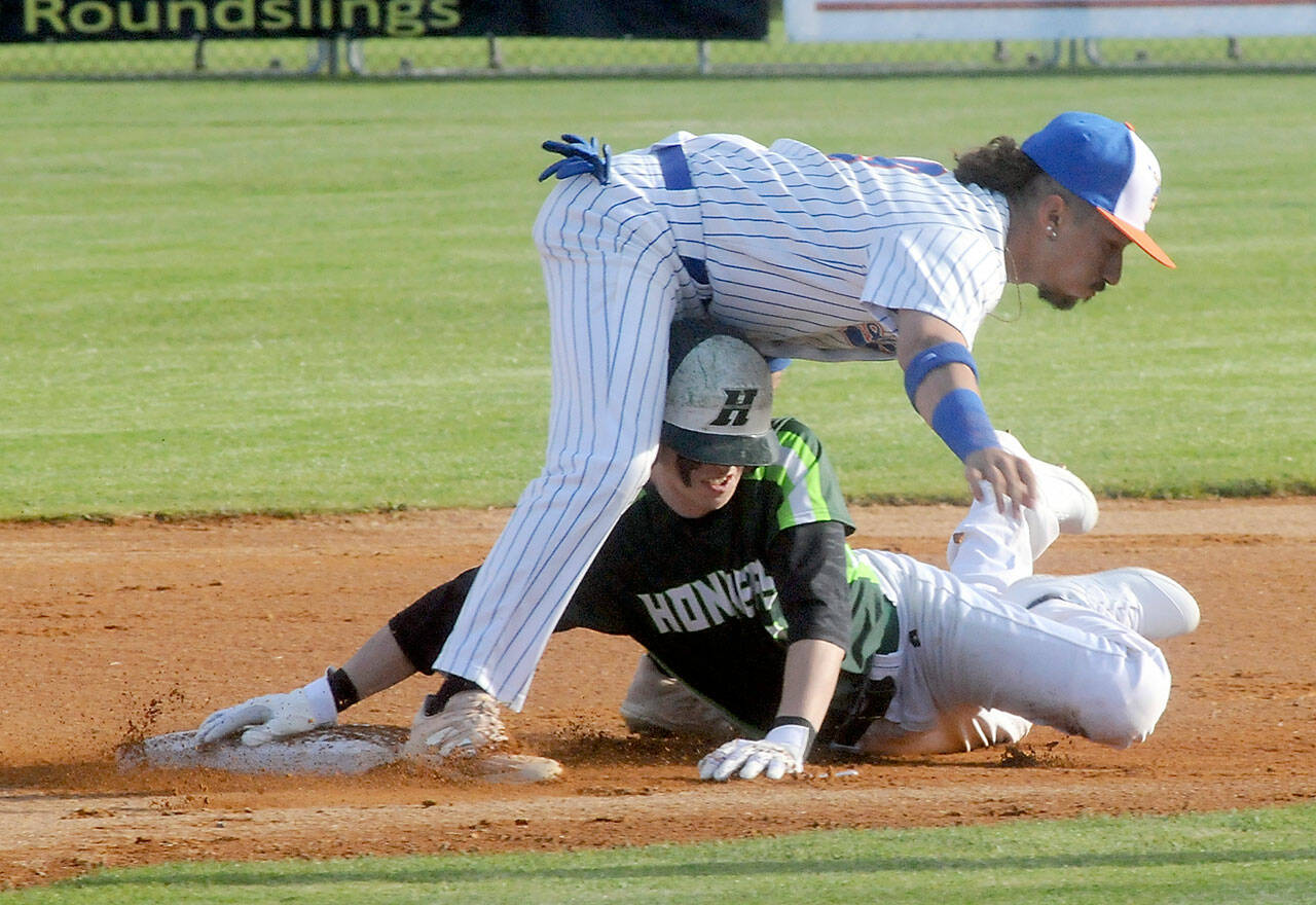 Lefties second baseman Gabriel DeJesus, top, stuggles to keep his balance after tagging out Northwest’s Jesse Bechtold on a steal attemp in the first inning on Friday evening at Port Angeles Civic Field. (Keith Thorpe/Peninsula Daily News)