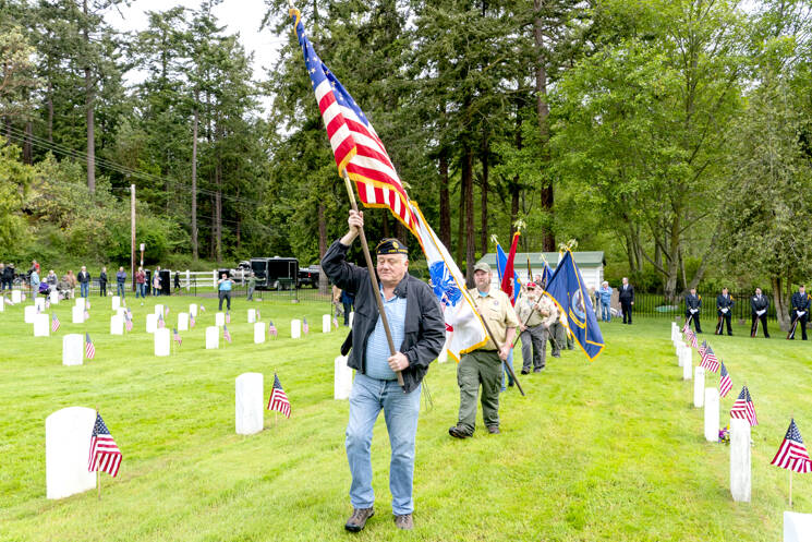 Dave Harrah, a former chaplain with American Legion Post 26 in Port Townsend, leads the color guard of scouts from Troop 1480 in Chimacum, to start the Memorial Day service at Fort Worden Military Cemetery on Monday. (Steve Mullensky/for Peninsula Daily News)