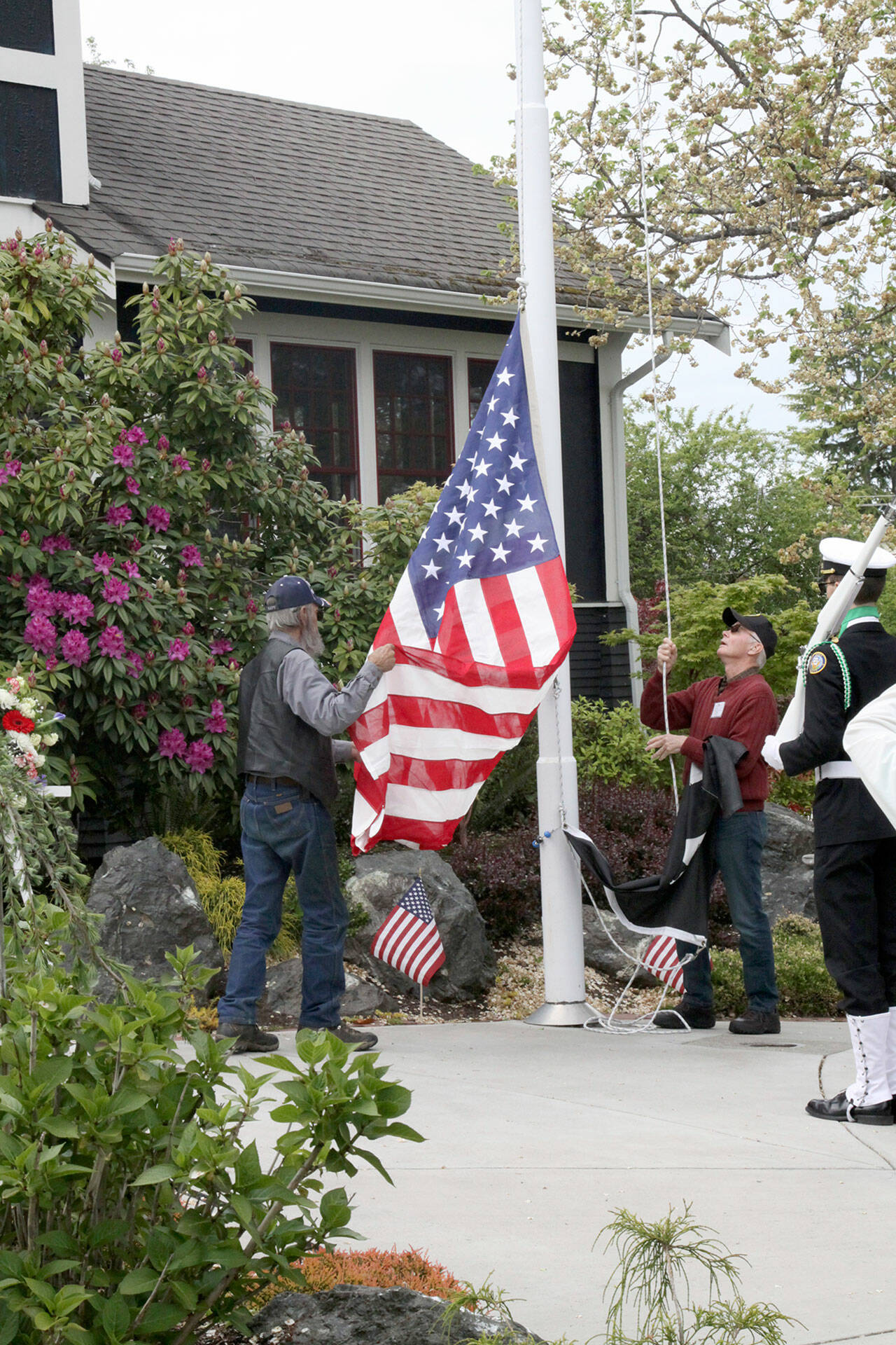 David Logan/for Peninsula Daily News
Raising their late father’s U.S. Flag over the Captain Joseph House on Memorial Day are Walter Johnson, left, and Norris Johnson, right.
