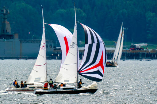 A pair of sloops race to the finish line as the Port Townsend Sailing Association’s Classic Mariners Regatta got underway. The 39th regatta returned after a two-year hiatus due to the COVID-19 pandemic. About 30 sailing vessels, large and small, took part in the annual sailing event Saturday that was open to all designs and materials for the first time. (Steve Mullensky/for Peninsula Daily News)
