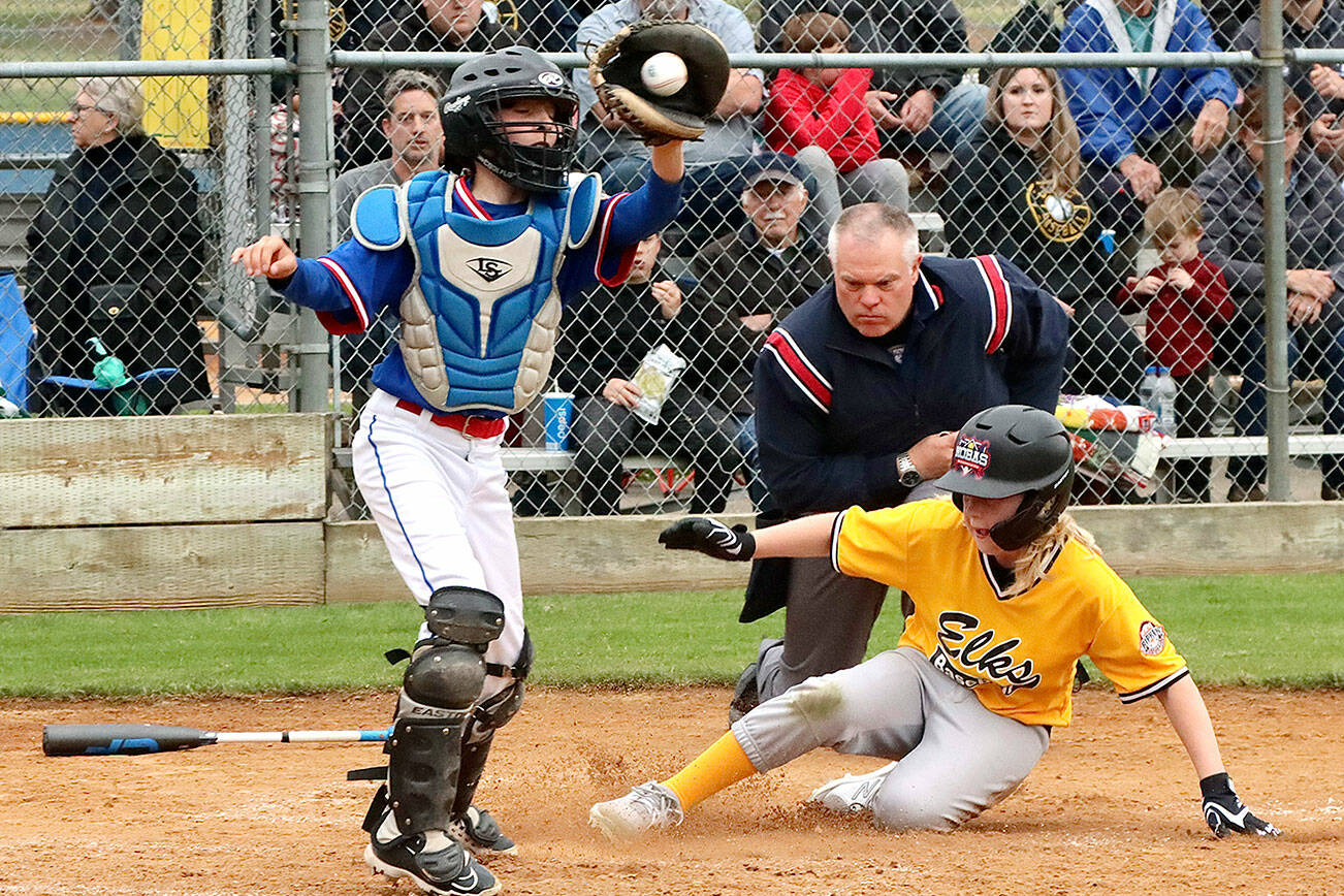 Ben Clemens slides safely into home as the Eagles catcher Felix Gonzales is a little late getting the ball from the outfield to make the tag. Ben Clemens scored the Elks both runs but they came up short as the Eagles flew past them 7 to 2 in the championship game Tuesday at the Lincoln Park complex dlogan