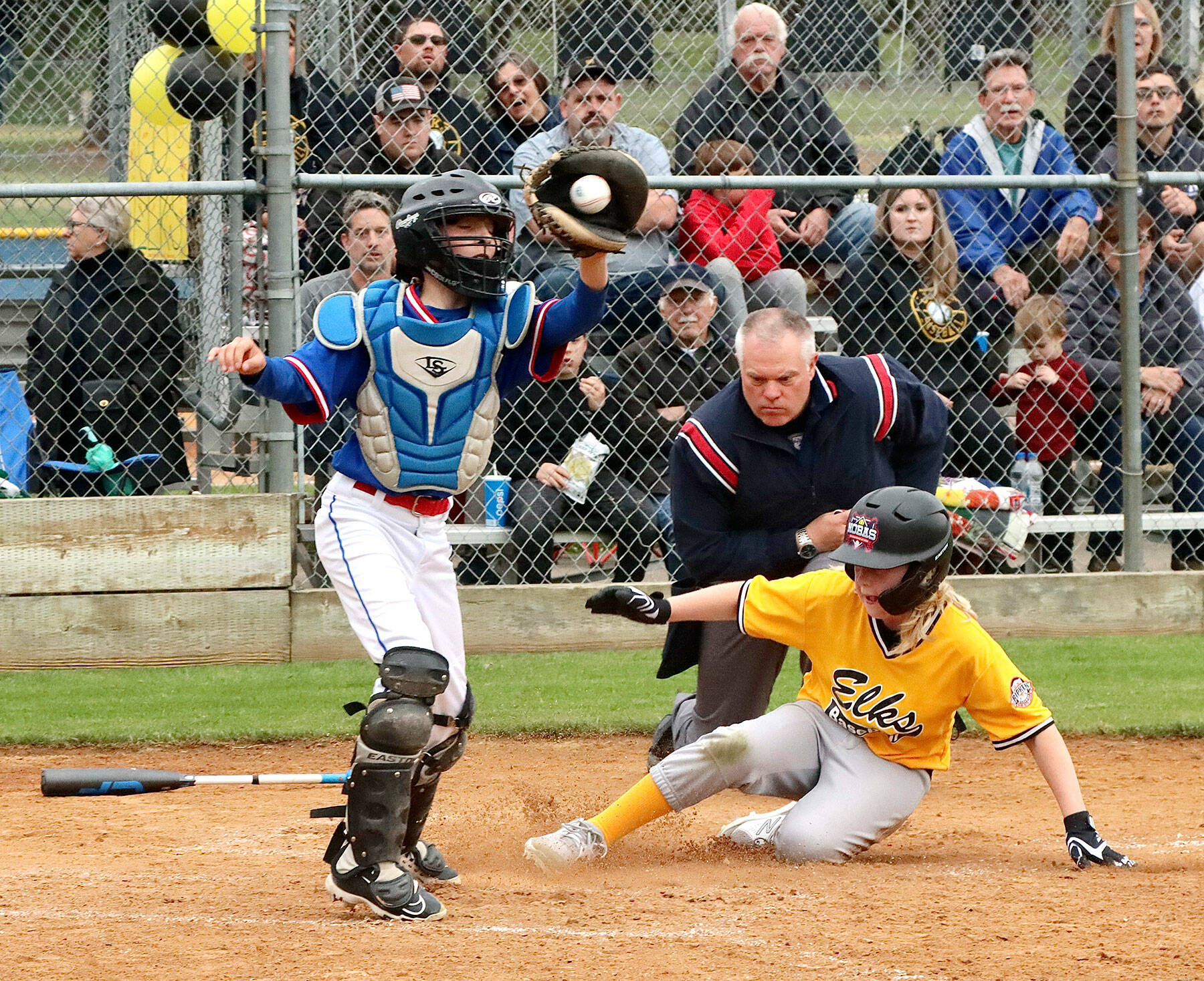 Elks’ Ben Clemens slides safely into home as the Eagles catcher Felix Gonzales gets the ball from the outfield to make the tag. Clemens scored two runs but the Eagles were able to win the Cal Ripken city championship game 7-2 Tuesday at the Lincoln Park complex. (Dave Logan/For Peninsula Daily News)