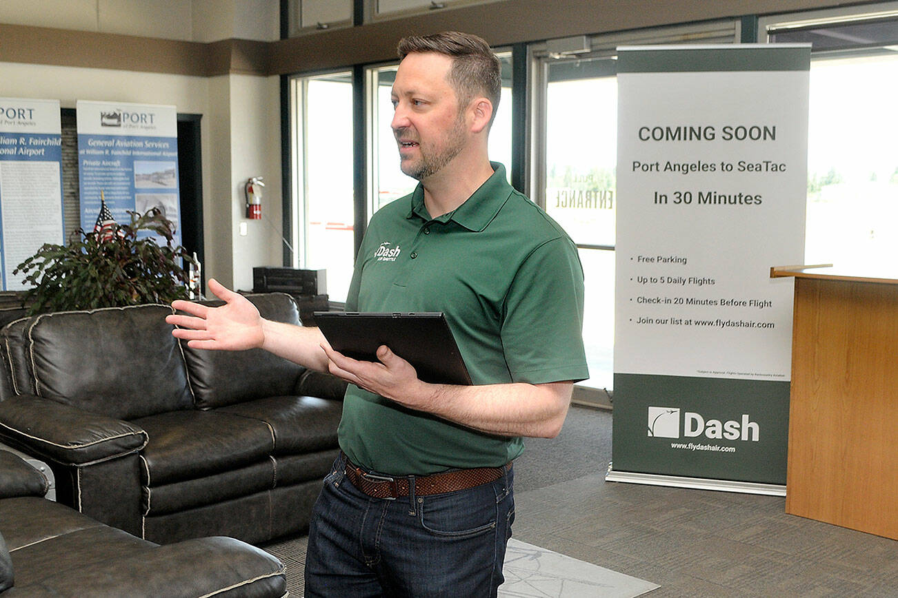 Clint Ostler, president of Dash Air Shuttle, announces details of the startup airline’s plans to begin service between Port Angeles and SeaTac Airport in Seattle during a gathering of Port of Port Angeles commissioners and others on Tuesday at William R. Fairchild International Airport. (Keith Thorpe/Peninsula Daily News)