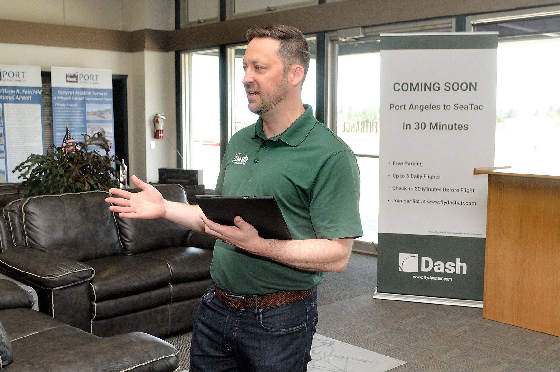 Clint Ostler, president of Dash Air Shuttle, announces details of the startup airline’s plans to begin service between Port Angeles and SeaTac Airport in Seattle during a gathering of Port of Port Angeles commissioners and others on Tuesday at William R. Fairchild International Airport. (Keith Thorpe/Peninsula Daily News)