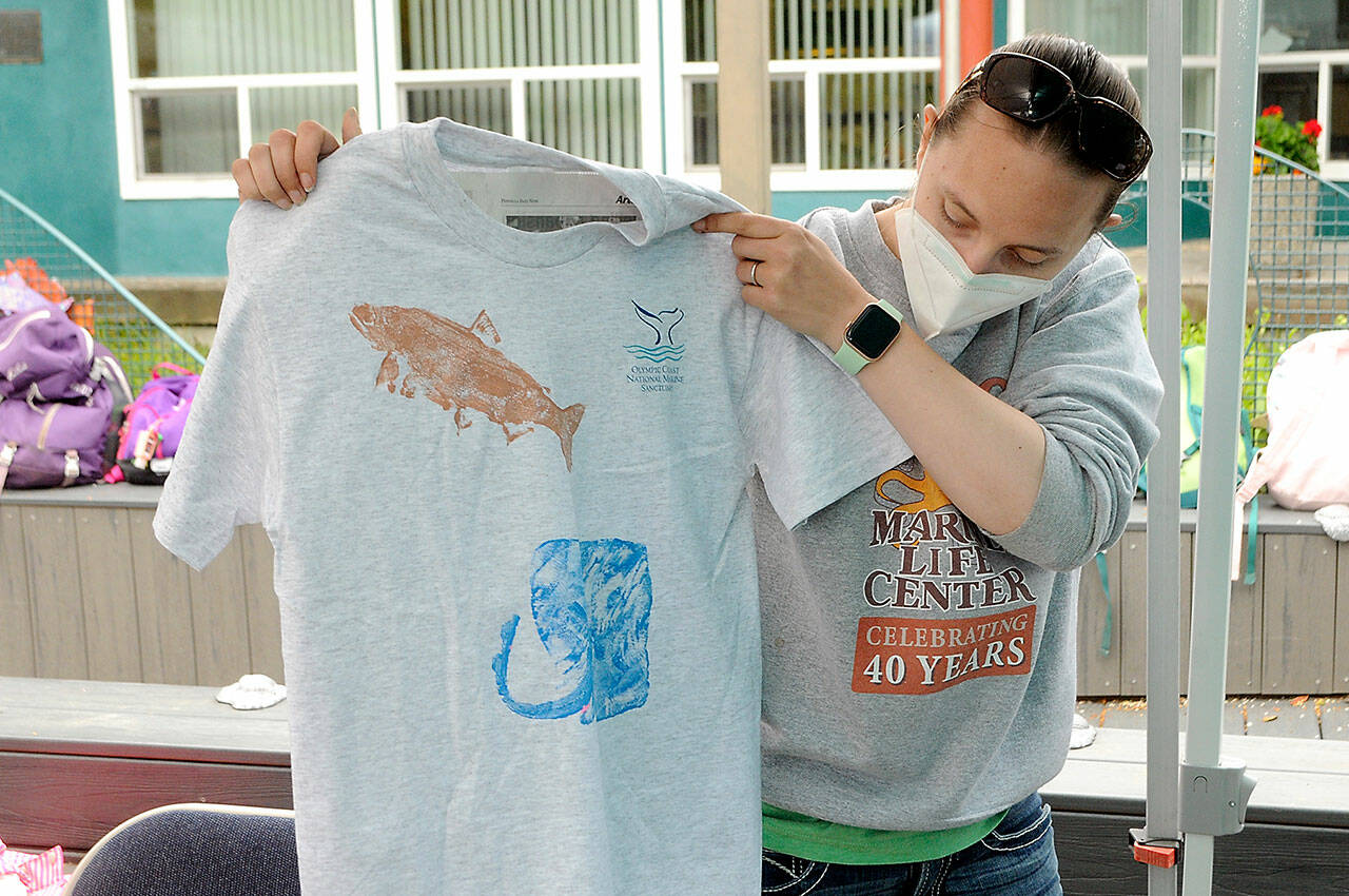 Rachele Brown, education manager for Feiro Marine Life Center in Port Angeles, displays a fish print shirt she had just created during the seasonal Junior Oceanographer summer camp for youngsters. (Keith Thorpe/Peninsula Daily News)