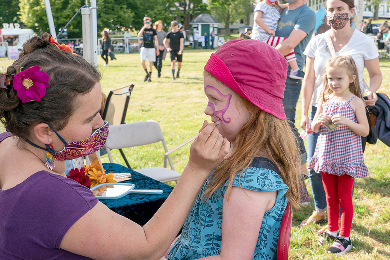 The Field Day event at Fort Worden State Park had something for everyone, including Port Townsend’s Rosie Dunham, 6, who is getting her face painted by artist Alexa Rose. Other activities Saturday included tug-o-war, music, bouncy houses and delicious foods. (Steve Mullensky/for Peninsula Daily News)