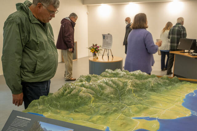 Visitors get a look at the Dungeness River Nature Center’s 3-D Dungeness River watershed table relief map. The center hosts open houses this week. (John Gussman/Jamestown S’Klallam Tribe)