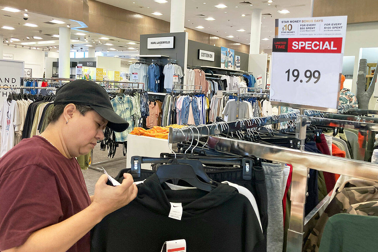 A customer checks price tags as she shops at a retail store in Schaumburg, Ill., Thursday, June 30, 2022. (AP Photo/Nam Y. Huh)