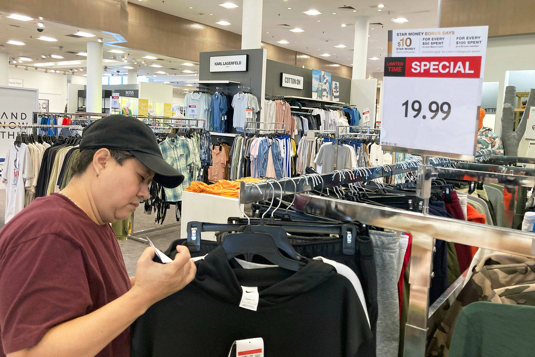 A customer checks price tags as she shops at a retail store in Schaumburg, Ill., Thursday, June 30, 2022. (AP Photo/Nam Y. Huh)
