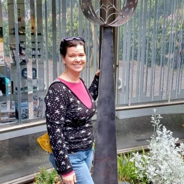 Karen Sixkiller poses with her Water Spider sculpture.