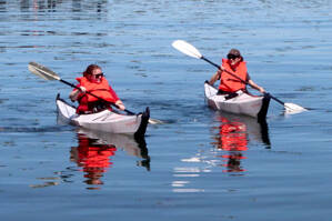 Amelia Kalagher of Port Angeles, left, and Jaedy Lee of Boston kayak near City Pier in Port Angeles on a clear day with Mount Baker off in the distance. Temperatures are forecast for the mid- to upper 60s for the rest of the week, with clouds moving in by Friday. (Dave Logan/for Peninsula Daily News)