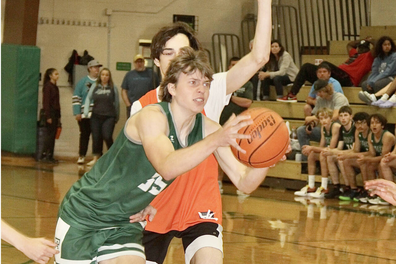 Port Angeles' Parker Nickerson muscles his way to the basket around a Central Kitsap defender during the Port Angeles summer basketball tournament Sunday. (Dave Logan/for Peninsula Daily News)
