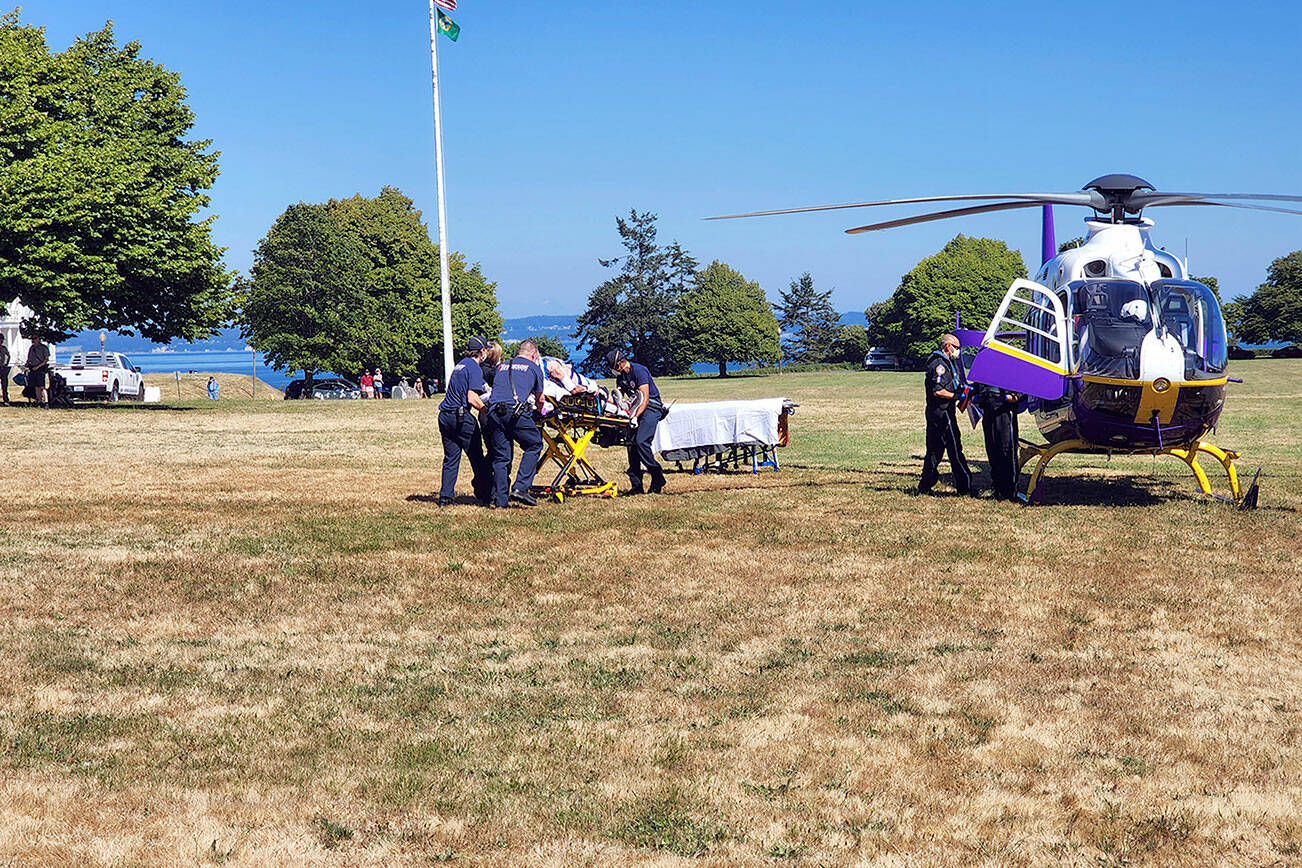 East Jefferson Fire Rescue personnel assist with loading an injured hiker onto a helicopter from Harborview Medical Center in Seattle on Tuesday afternoon. The unidentified elderly man had fallen on a trail by Fort Worden’s Battery Tolles. (East Jefferson Fire Rescue)