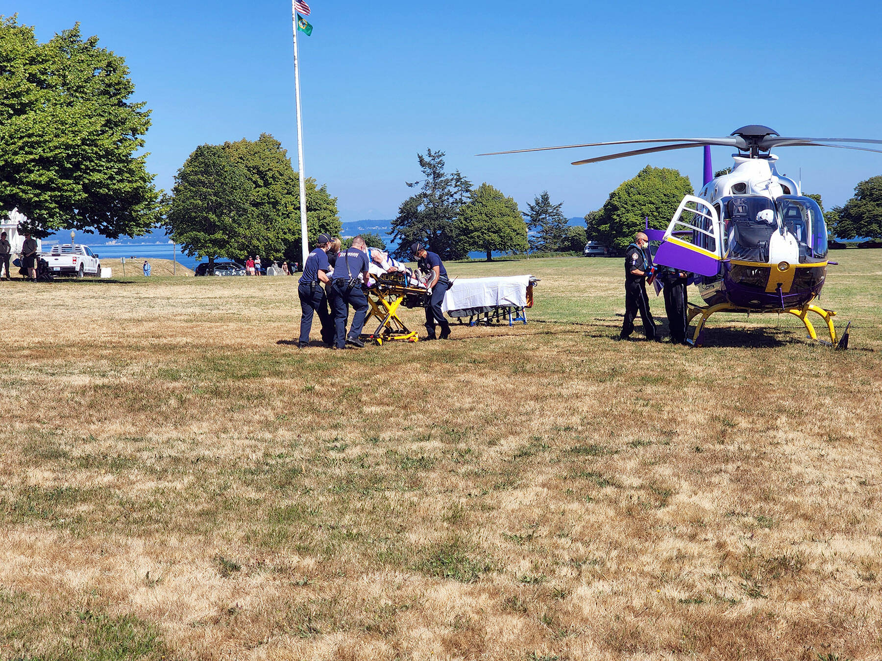 East Jefferson Fire Rescue personnel assist with loading an injured hiker onto a helicopter from Harborview Medical Center in Seattle on Tuesday afternoon. The unidentified elderly man had fallen on a trail by Fort Worden’s Battery Tolles. (East Jefferson Fire Rescue)