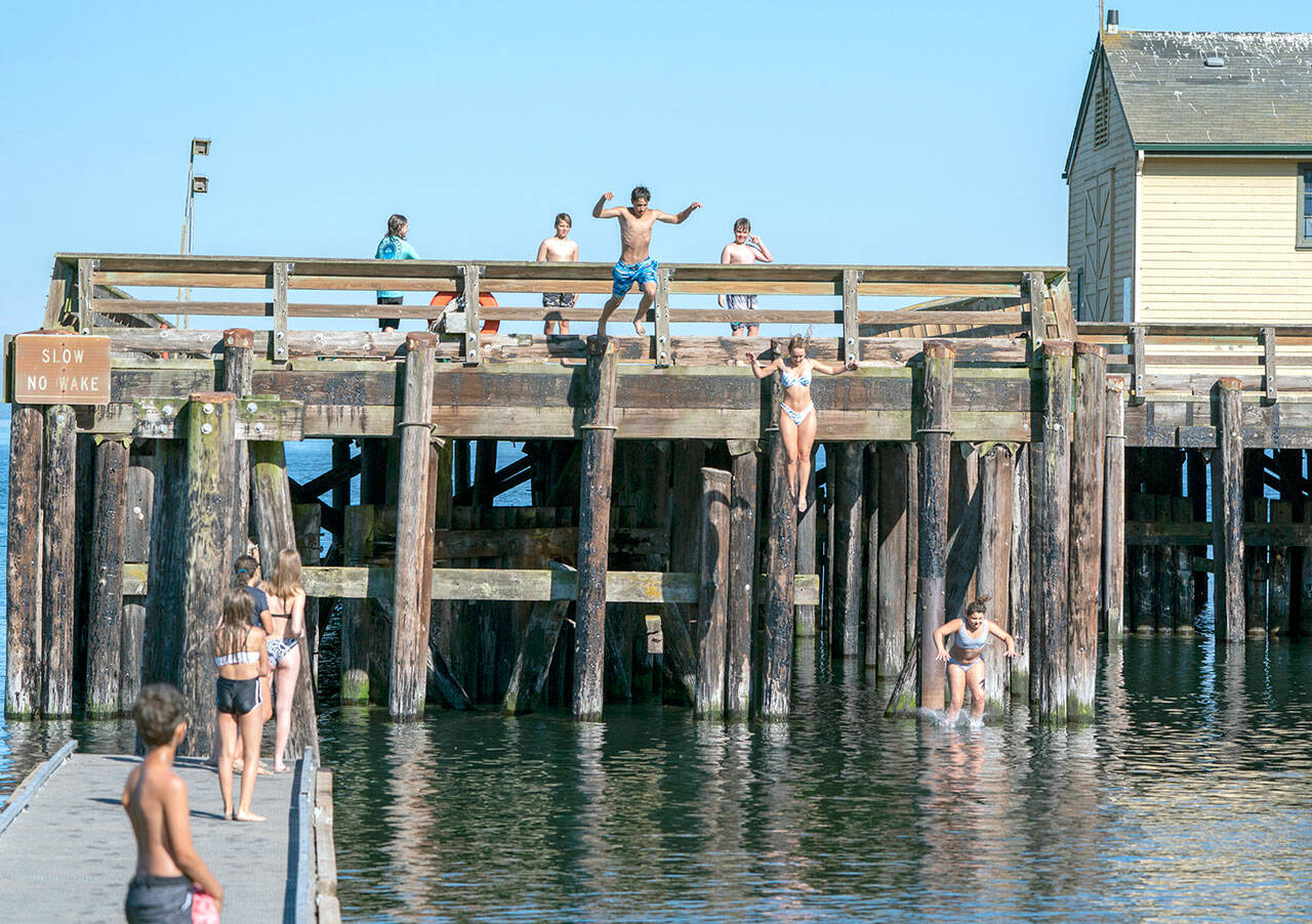 A group of youths cool off by jumping into the cove at the Marine Science Center at Fort Worden State Park on Tuesday. (Steve Mullensky/for Peninsula Daily News)