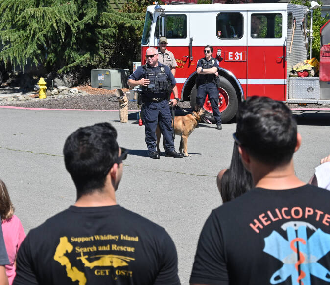 Kevin Miller, Port Angeles Police Department officer, offers a K-9 demonstration as Kitsap County Sheriff’s Office deputy Aaron Baker. and Port Angeles police officer Whitney Fairbanks look on. (Michael Dashiell/Olympic Peninsula News Group)
