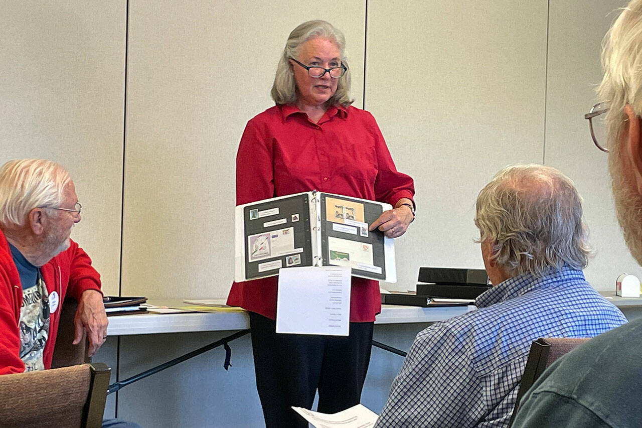 Cathie Osborn, show organizer of the Strait Stamp Show on Saturday, shares some stamps with bells as part of a show-and-tell at the Strait Stamp Society’s monthly meeting. She said the Sequim show features 20 exhibits, seven dealers and giveaways. (Matthew Nash/Olympic Peninsula News Group)