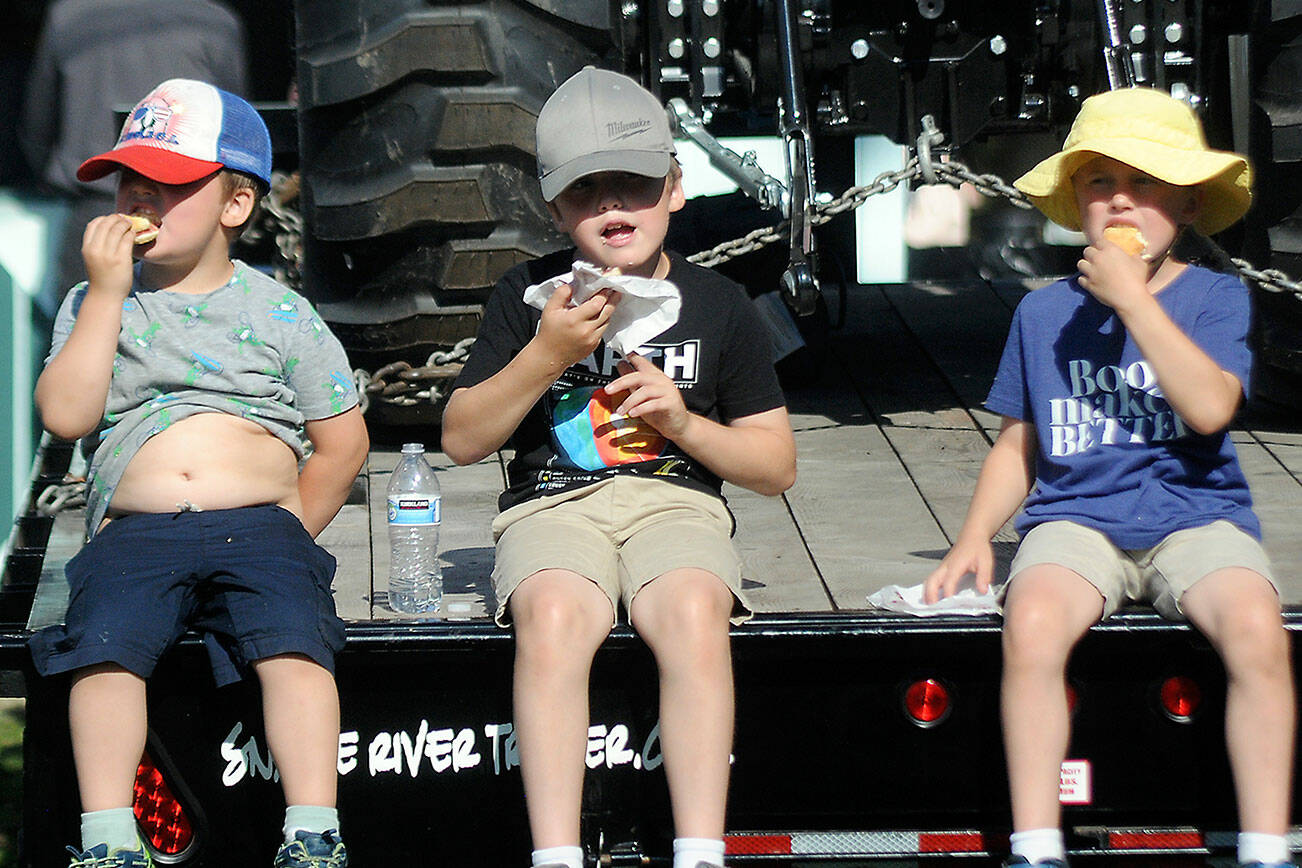 Keith Thorpe/Peninsula Daily News
Siblings, from left, Charlie Jones, 4, Samuel Jones, 8, and August Jones, 6, all of Port Angeles, eat fresh scones on Thursday at the Clallam County Fair.