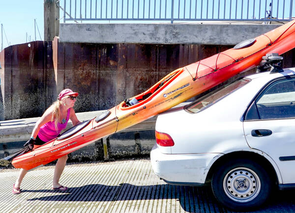 Jennifer Porter of Edmonds loads her 14-foot kayak after a morning on the water at Port Townsend Boat Haven on Monday. Porter attended the three-day THING Festival at Fort Worden State Park over the weekend and wanted to get some time on the water before going home. (Steve Mullensky/for Peninsula Daily News)
