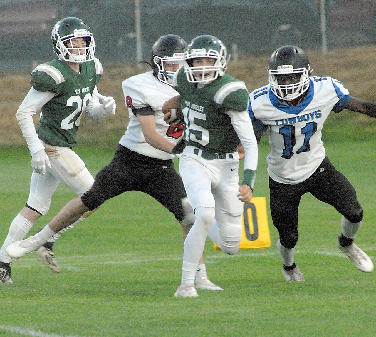 Port Angeles’ Parker Nickerson, center, slips past East Jefferson’s Lonnie Kenney and Jerome Reaux Jr., right, as Nickerson’s teammate, Brantyn Fisler, left, follows behind on Friday at Port Angeles Civic Field. (Keith Thorpe/Peninsula Daily News)