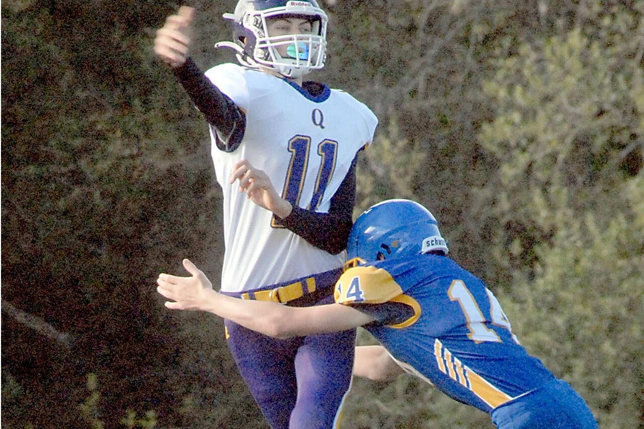 Quilcene quaterback Nathan Kieffer passes before being tackled by Crescent’s Cole Grooms on Thursday at Crescent High School. (Keith Thorpe/Peninsula Daily News)