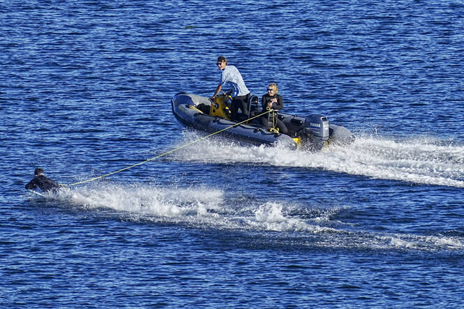 A belly board rider gets a slingshot boost and zooms almost ahead of the tow boat as they zip over the cooling waters of Port Townsend Bay. High temperatures are expected to remain in the 70s through Labor Day weekend. (Steve Mullensky/for Peninsula Daily News)