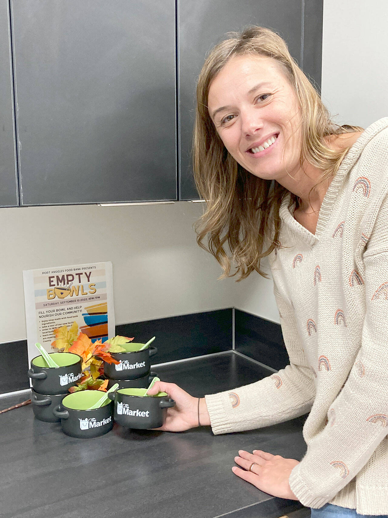 Hermina Solomon, the Port Angeles Food Bank assistant director, shows off bowls that visitors can acquire at the Empty Bowls Fundraiser.