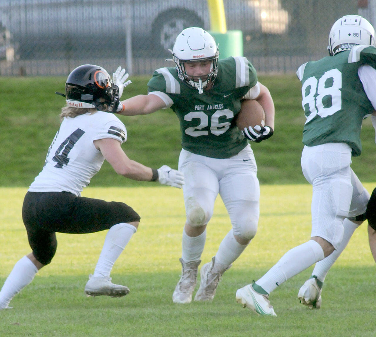 Port Angelesâ Landyn Jones, center, pushes off a Blaine defender after receiving a block from teammate Cole Beeman, right, on Friday in Port Angeles. Jones gained 82 yards rushing last week, much of it on misdirection plays. (Keith Thorpe/Peninsula Daily News)