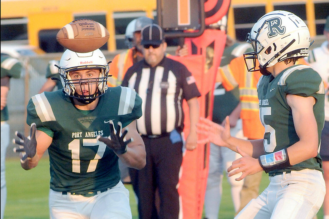 Keith Thorpe/Peninsula Daily News
Port Angeles' Jason Hawes, left, takes a backfield toss from quarterback Parker Nickerson during Friday night's game against Anacortes at Port Angeles Civic Field.