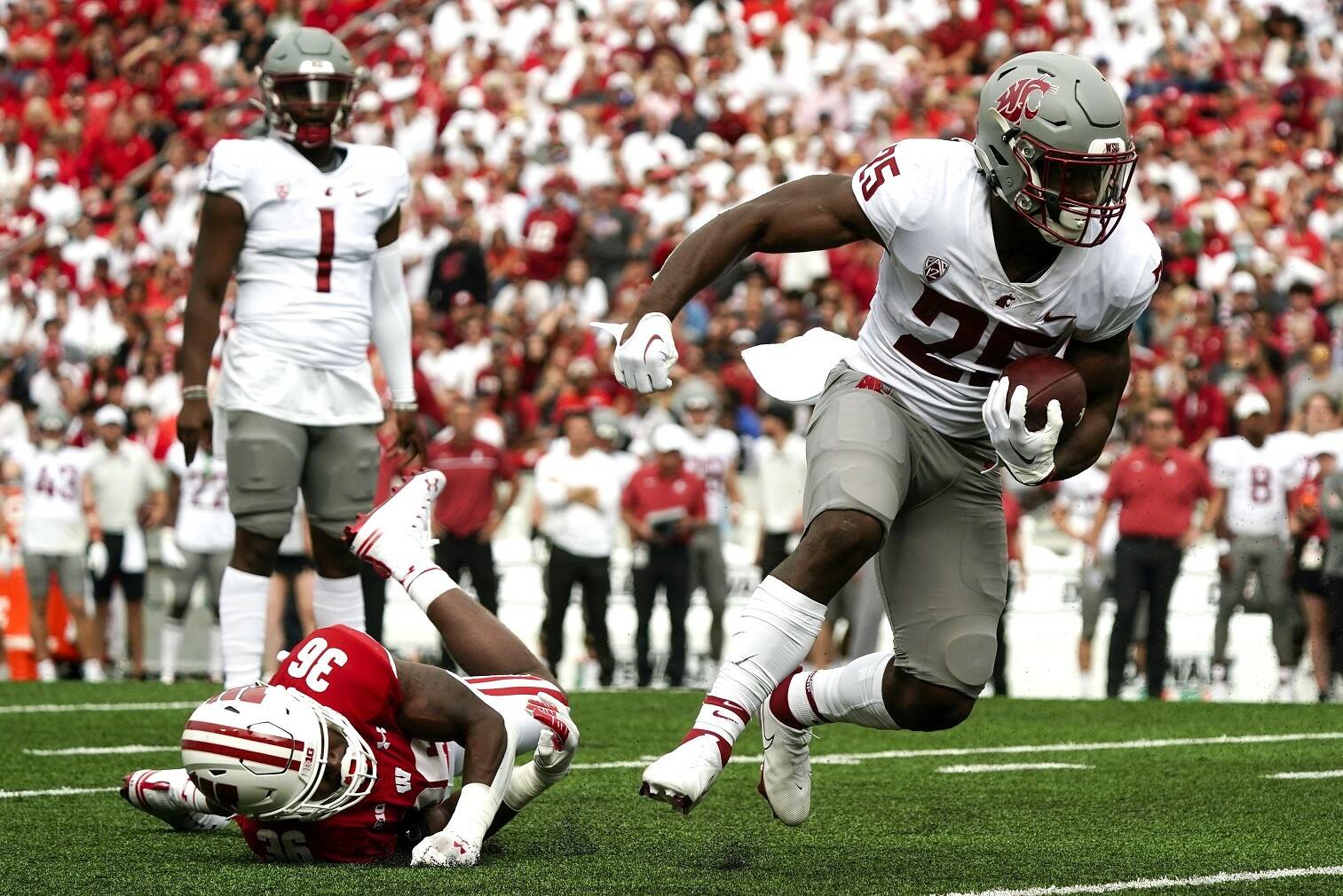 Washington State's Nakia Watson (25) runs past Wisconsin's Jake Chaney (36) during the first half of an NCAA college football game Saturday in Madison, Wis. (AP Photo/Morry Gash)