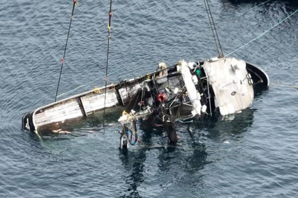 The Aleutian Isle lays on its side suspended by crane after being lifted to the surface on Saturday. (Canada Dept. of Fisheries and Oceans)