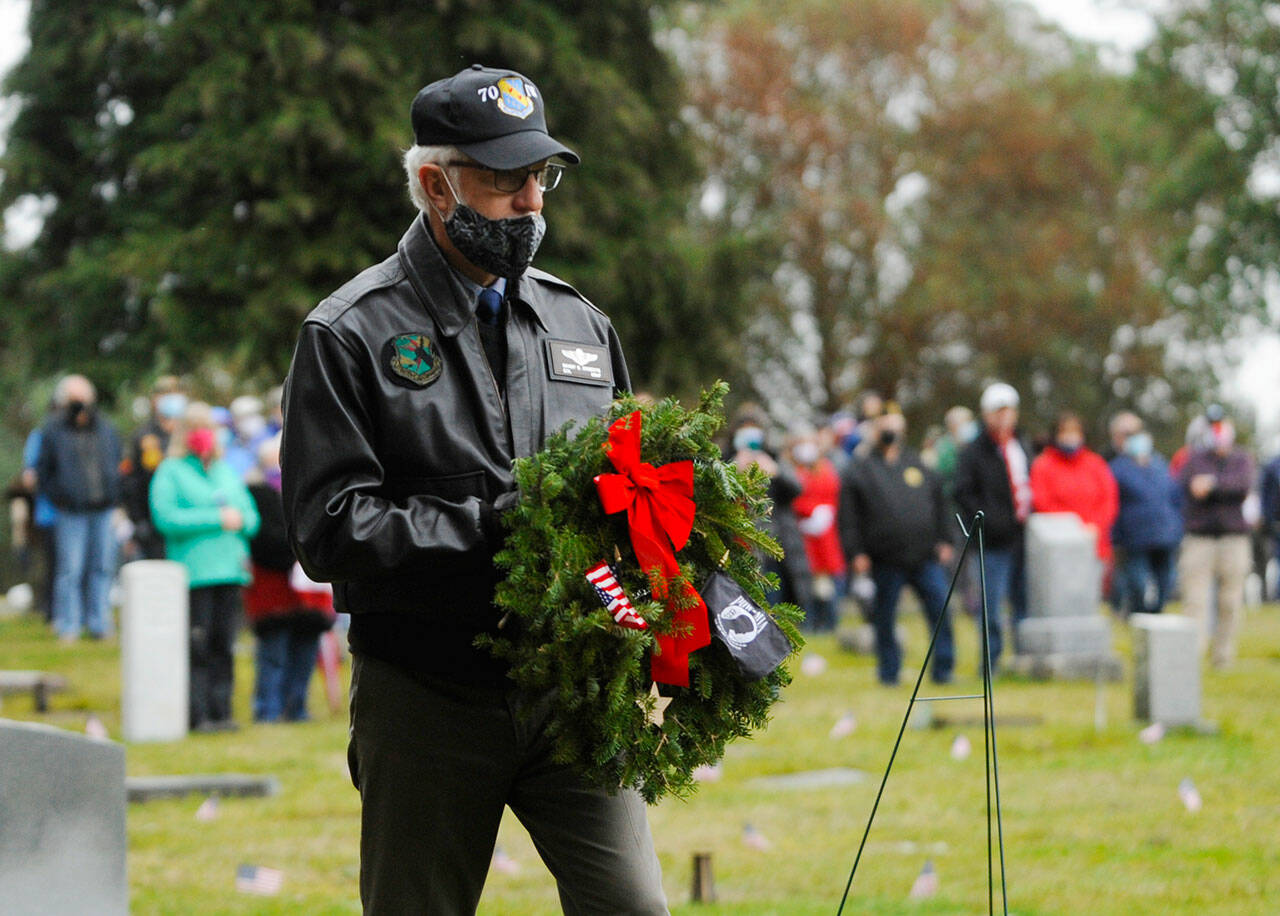 Col. Randy Roberts (U.S. Air Force, ret.) prepares to lay a ceremonial wreath for U.S. military prisoners of war and missing in action at a Wreaths Across American event at Sequim View Cemetery in 2020. (Michael Dashiell/Olympic Peninsula News Group)