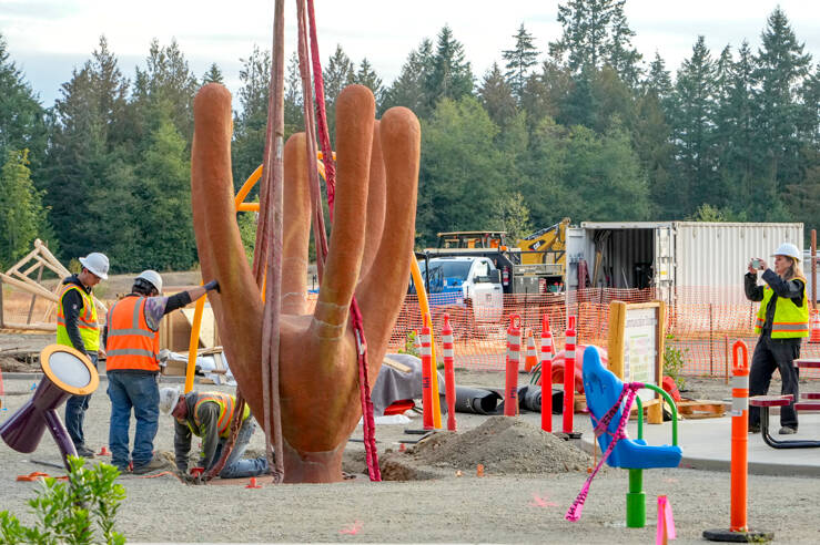Port Townsend artist Rebecca Welti records the installation of her concrete climbing sculpture, Pluteus, at a new playground area at HJ Carroll Park in Chimacum. The sculpture, in the shape of a baby sea urchin, is totally accessible and represents dependence on life in the Salish Sea. (Steve Mullensky/for Peninsula Daily News)