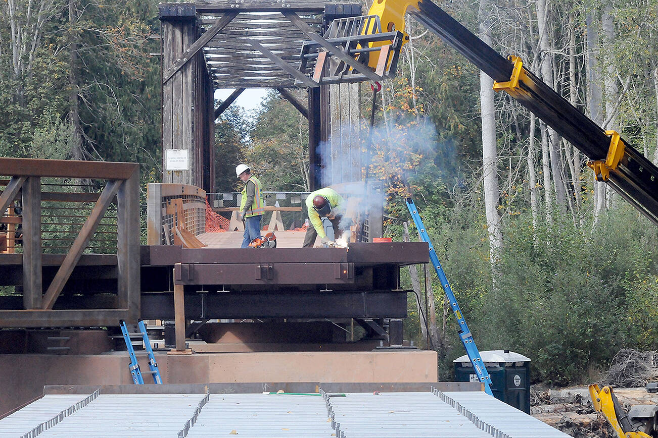 KEITH THORPE/PENINSULA DAILY NEWS
A construction worker welds support pieces for a new pedestrian bridge connecting the historic railroad trestle over the Dungeness River to the Dungeness River Nature Center at Railroad Bridge Park in Sequim on Wednesday. The work is part of a project to restore part of the original Dungeness River floodplain while providing better access to the Olympic Discovery Trail.
