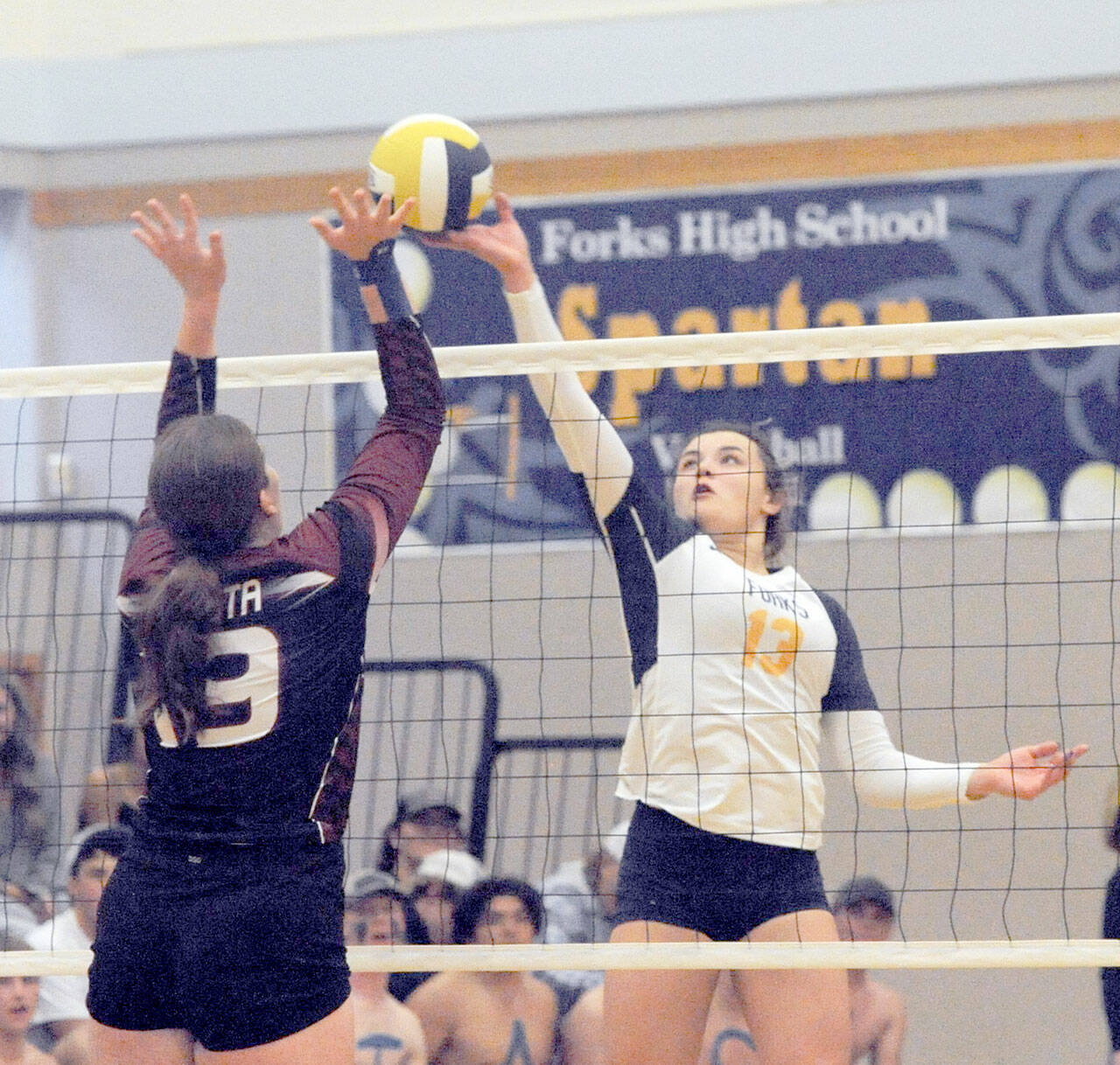Lonnie Archibald/for Peninsula Daily News Forks’ Kaidence Rigby (13) competes with Ocosta’s Alexia Bradley at the net during the Spartans’ 3-0 home sweep of the Wildcats on Thursday.