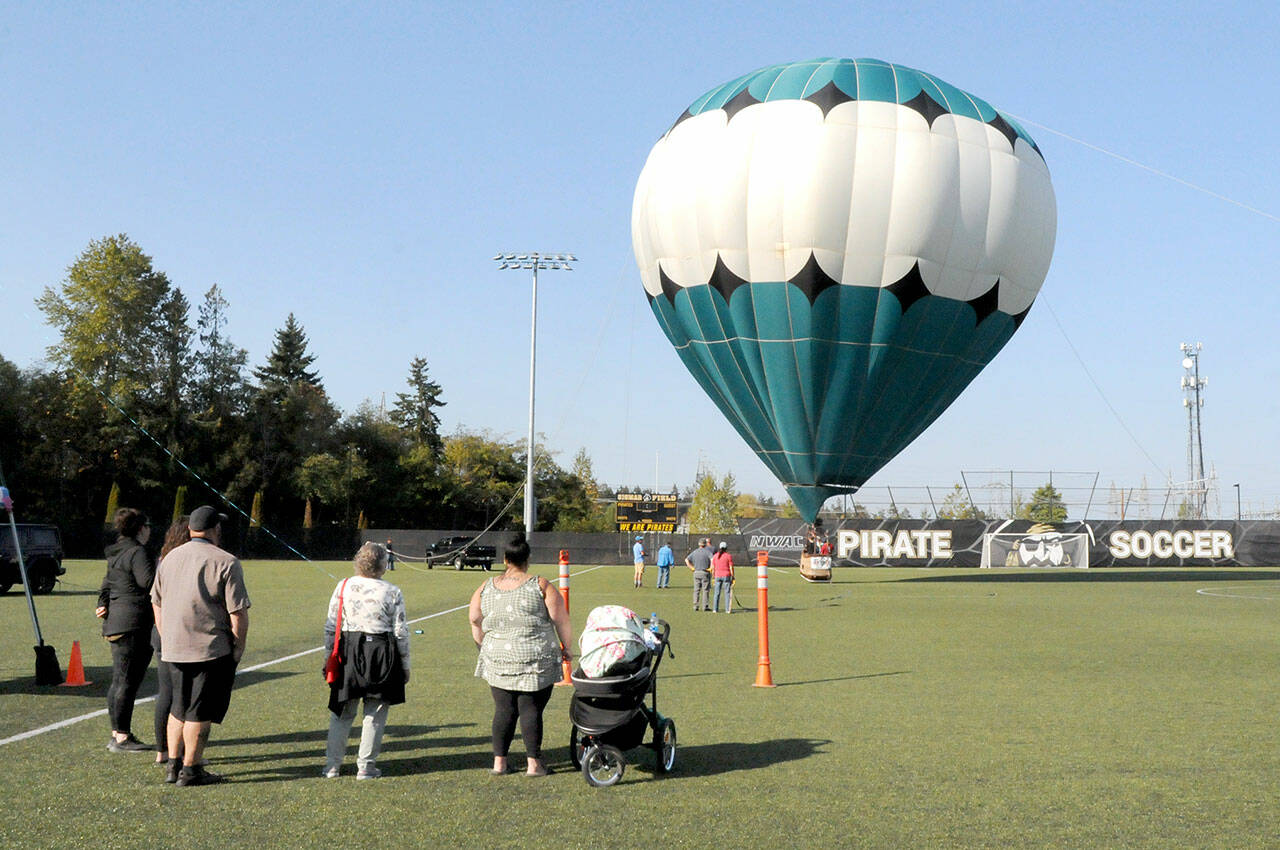 A hot air balloon rises from the soccer field of the Wally Sigmar Athletic Complex at Peninsula College in Port Angeles for tethered rides on Saturday as part of the Peninsula College Fall Spectacular. The event, hosted by the school to bring the community to the campus, also featured displays and demonstrations, children’s activities, food and music. (Keith Thorpe/Peninsula Daily News)