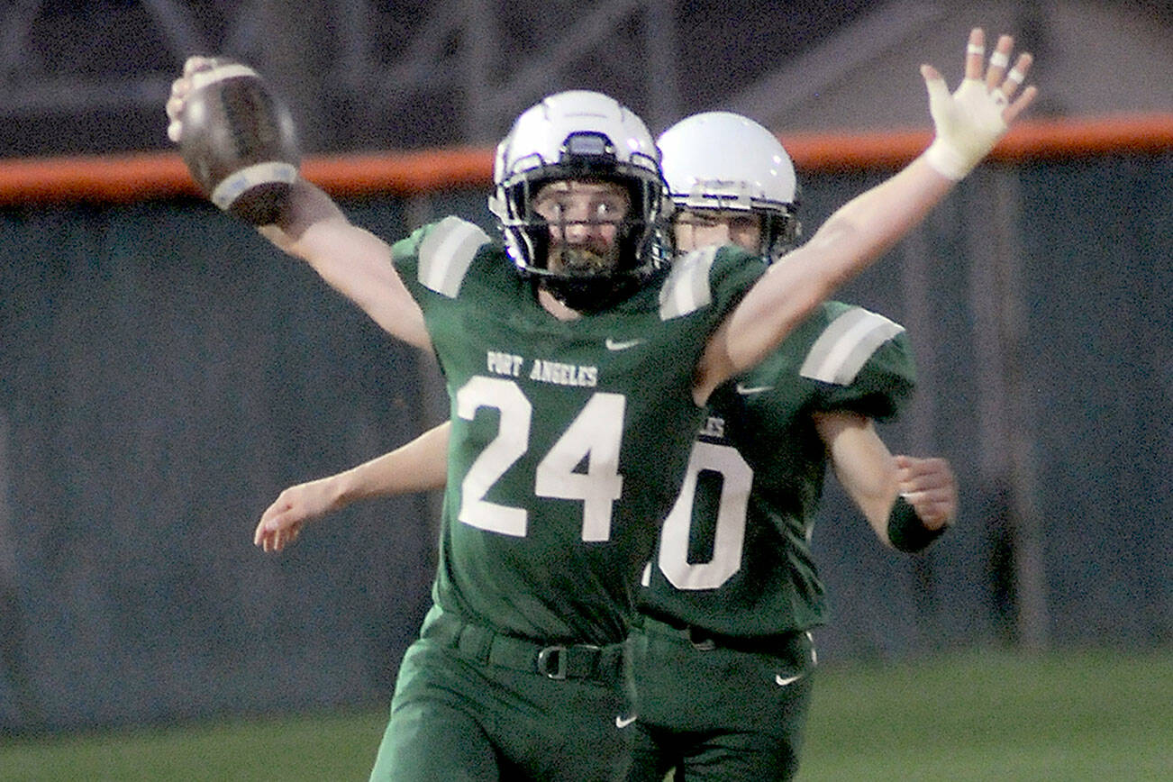 KEITH THORPE/PENINSULA DAILY NEWS
Port Angeles' James Browning, accompanied by teammate Xavier Nelson, celebrates a touchdown run after intercepting a pass from Bremerton's Aiga Logova in the first quarter on Friday night at Port Angeles Civic Field.