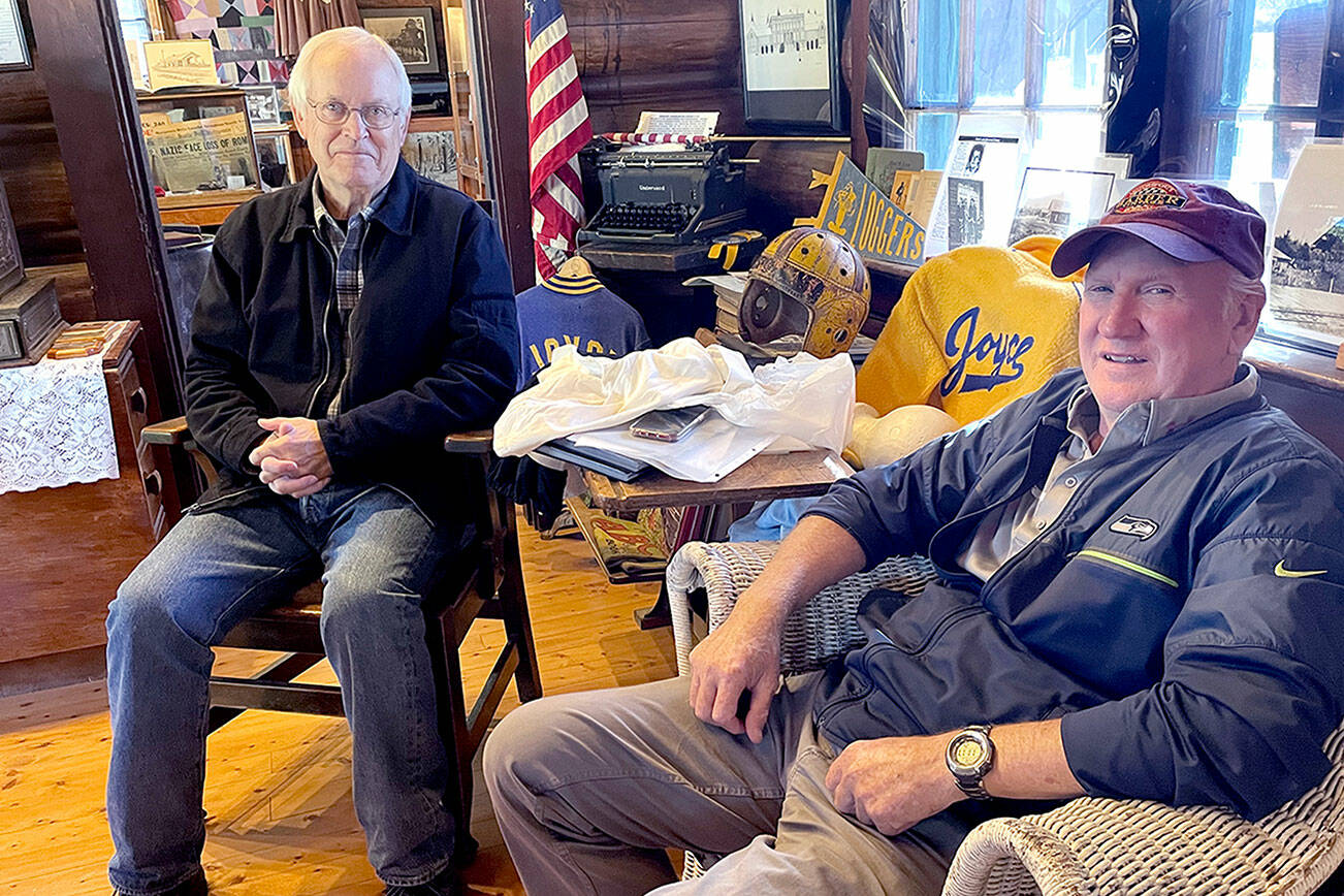 Dan Dafoe, left, and Terry Kahler, right, wrote a book, “Crescent School District 313, Joyce, Washington, 1922-1924,” that commemorates the history of the district, whose centennial will be celebrated Saturday. (Paula Hunt/Peninsula Daily News)