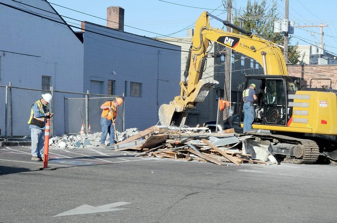 A construction crew last week goes over the remains of an aging public restroom in the parking lot between First and Front streets in the 100 block in downtown Port Angeles after it was demolished. (Keith Thorpe/Peninsula Daily News)