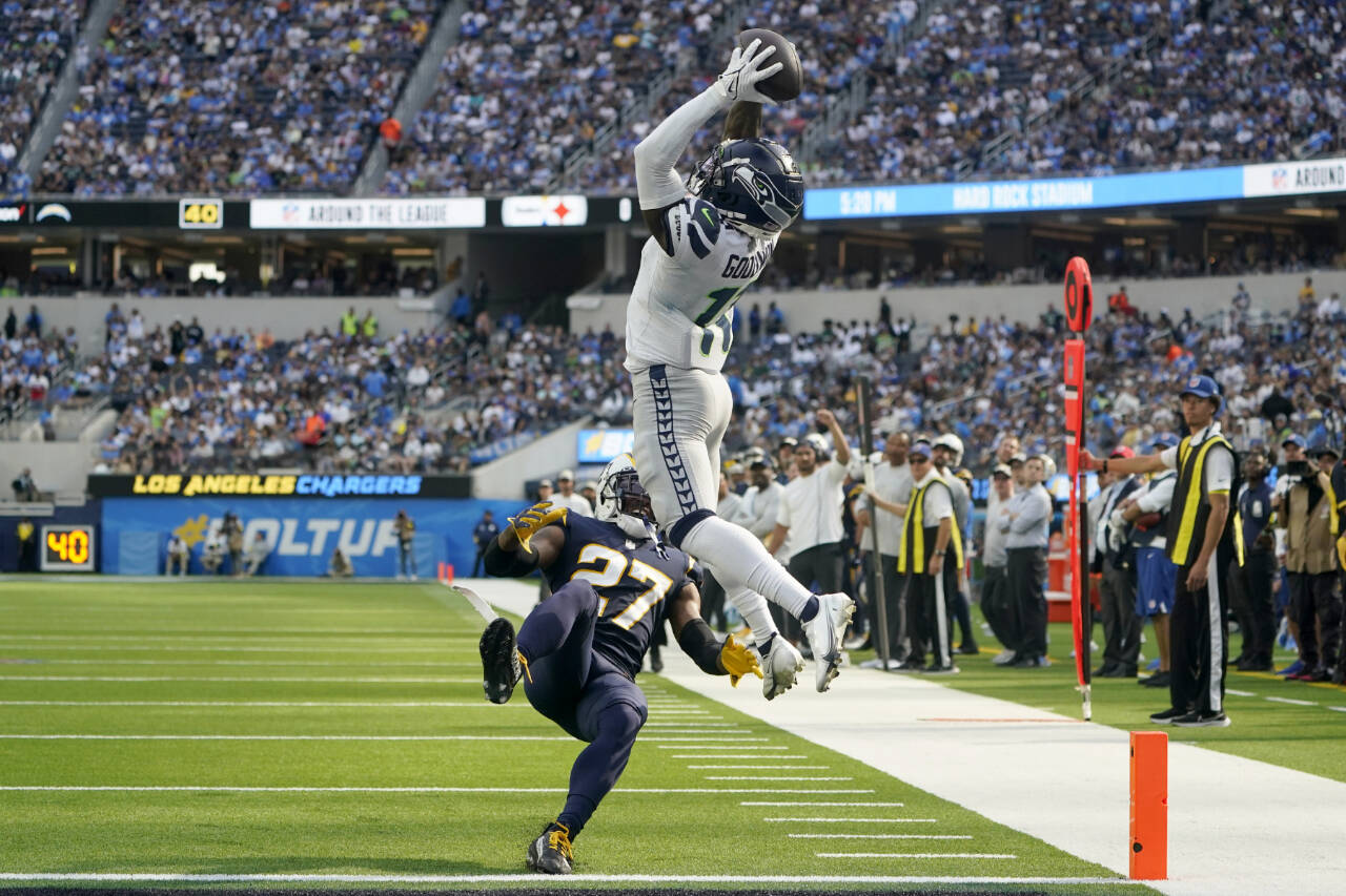Seattle Seahawks wide receiver Marquise Goodwin (11) catches a pass for a touchdown during the first half of an NFL football game against the Los Angeles Chargers Sunday, Oct. 23, 2022, in Inglewood, Calif. Los Angeles Chargers cornerback J.C. Jackson (27) falls with an injury. (AP Photo/Marcio Jose Sanchez)