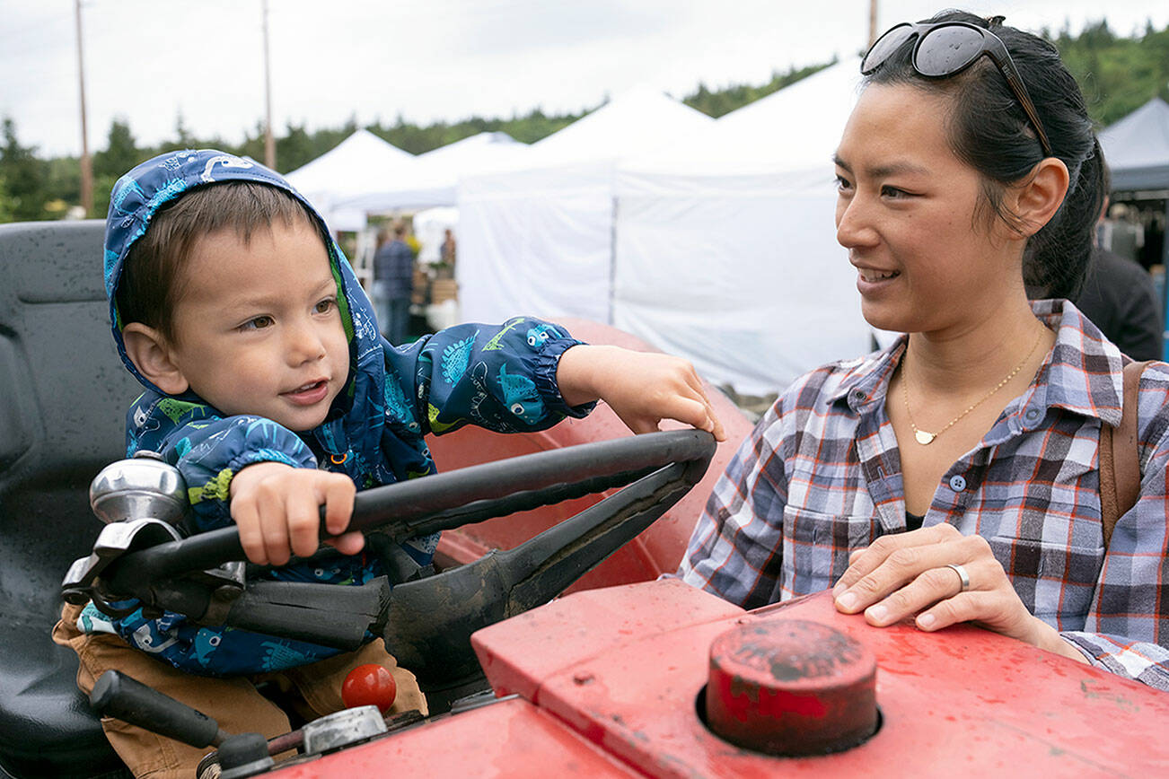 Vanessa Wade and her son enjoy the Chimacum Farmers Market earlier this season. Sunday is the last day before next summer. (David Conklin)