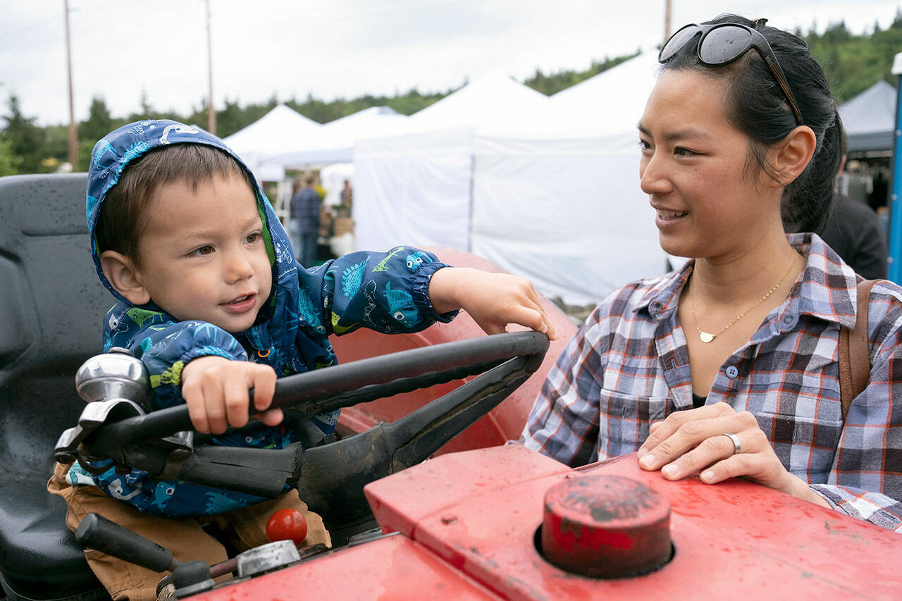 Vanessa Wade and her son enjoy the Chimacum Farmers Market earlier this season. Sunday is the last day before next summer. (David Conklin)
