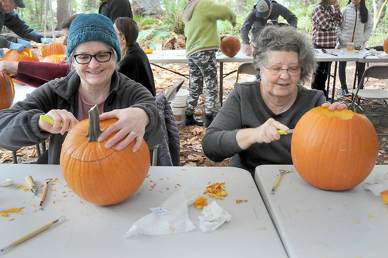 Kathy Durr, 70, left, and Charle Crocker, 69, both of Port Angeles, try their hands at carving jack-o-lanterns during a pumpkin carving workshop on Saturday at the Port Angeles Fine Arts Center. The workshop, which drew about 50 participants, was part of the center’s second annual Celebration of Shadows, a tribute to the season of Halloween. The event also included a mask-making workshop, a carved pumpkin contest, spooky walks and an outdoor movie. (Keith Thorpe/Peninsula Daily News)