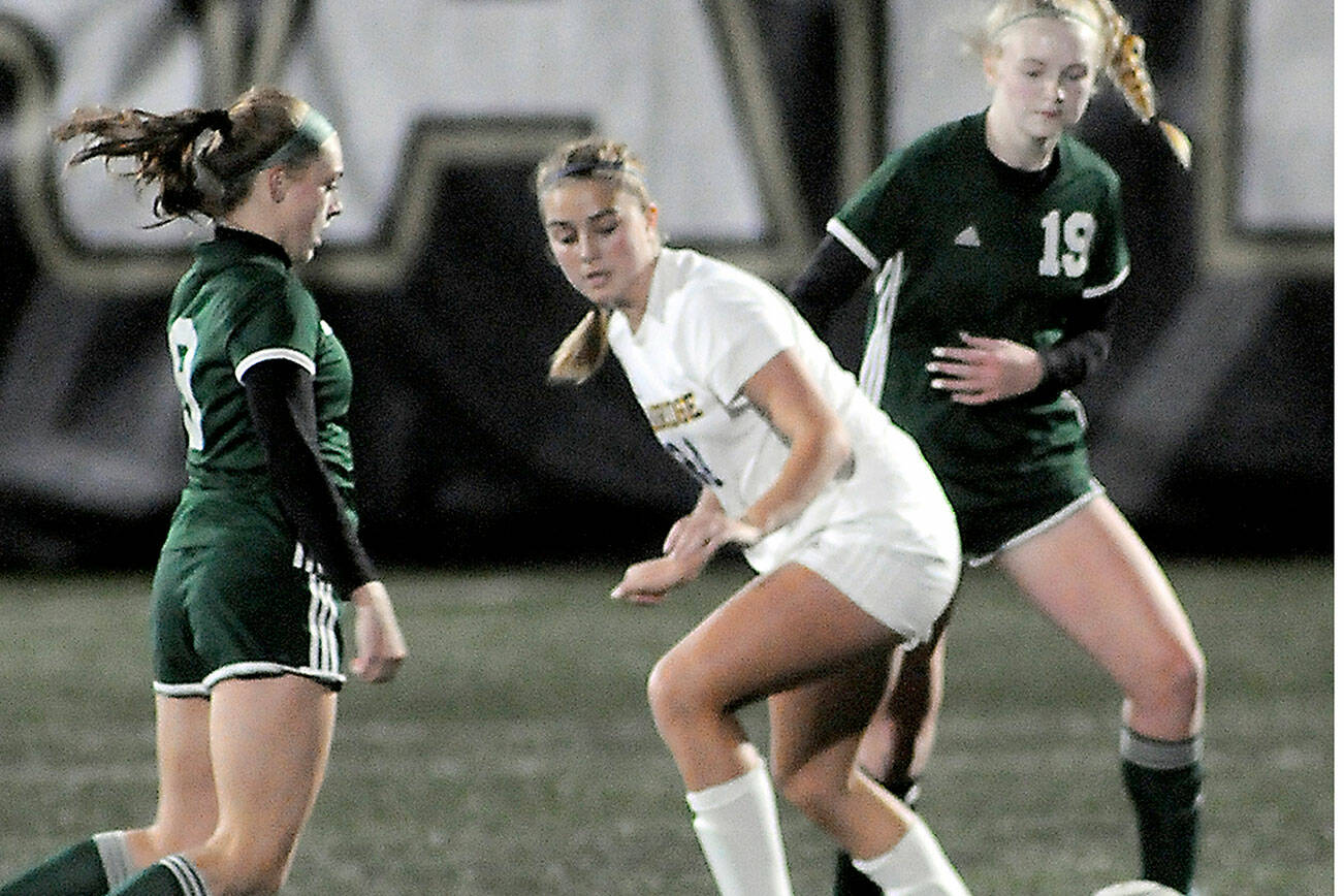KEITH THORPE/PENINSULA DAILY NEWS
Port Angeles' Teanna Clark, left, and Paige Mason, right, close in on Bainbridge's Grace Rich on Tuesday's match in Port Angeles.