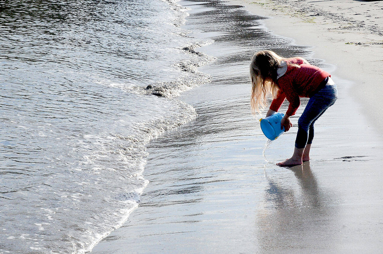 KEITH THORPE/PENINSULA DAILY NEWS
Four-year-old Marlee Sargent of Port Angeles plays with a bucket and water on Friday on the shore of Port Angeles Harbor. The youngster and her family were taking advantage of a warm autumn day to pay a visit to Hollywood Beach in Port Angeles.