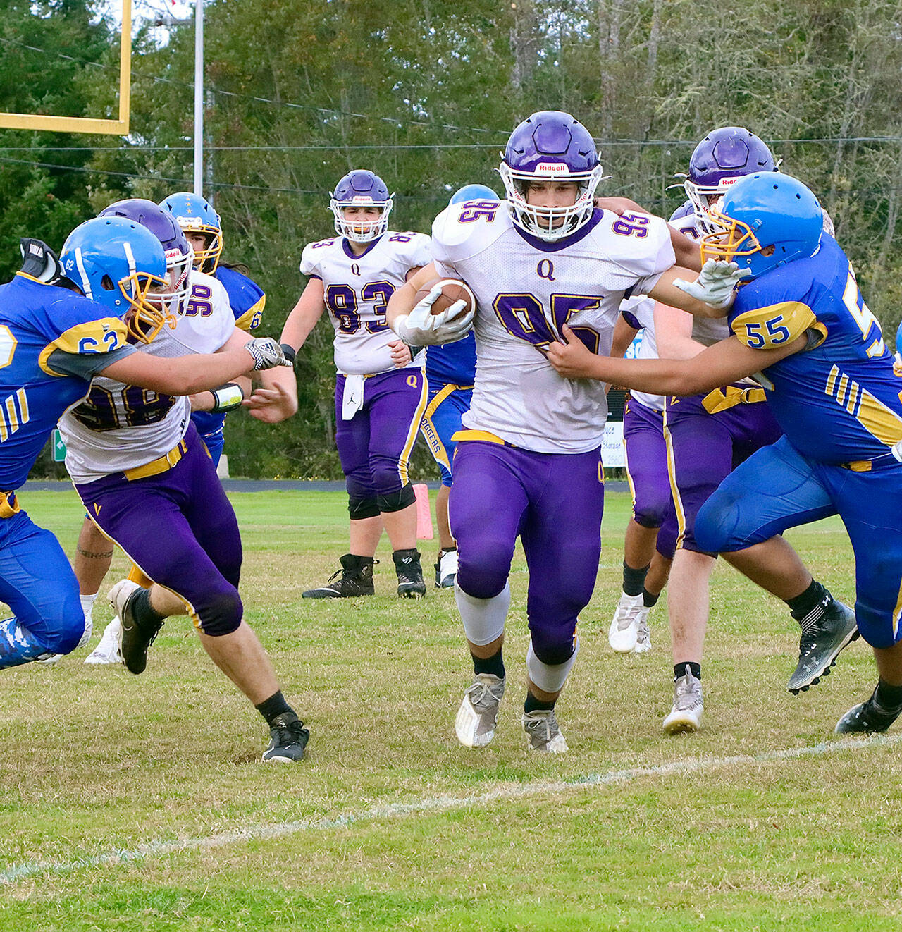 Quilcene’s Deakon Budnek (95) rumbles through the Crescent defense for a long gainer. Pursuing on the play for Crescent is Tommy Leonard (62) and Jeremy Charles (55). (Dave Logan/for Peninsula Daily News)