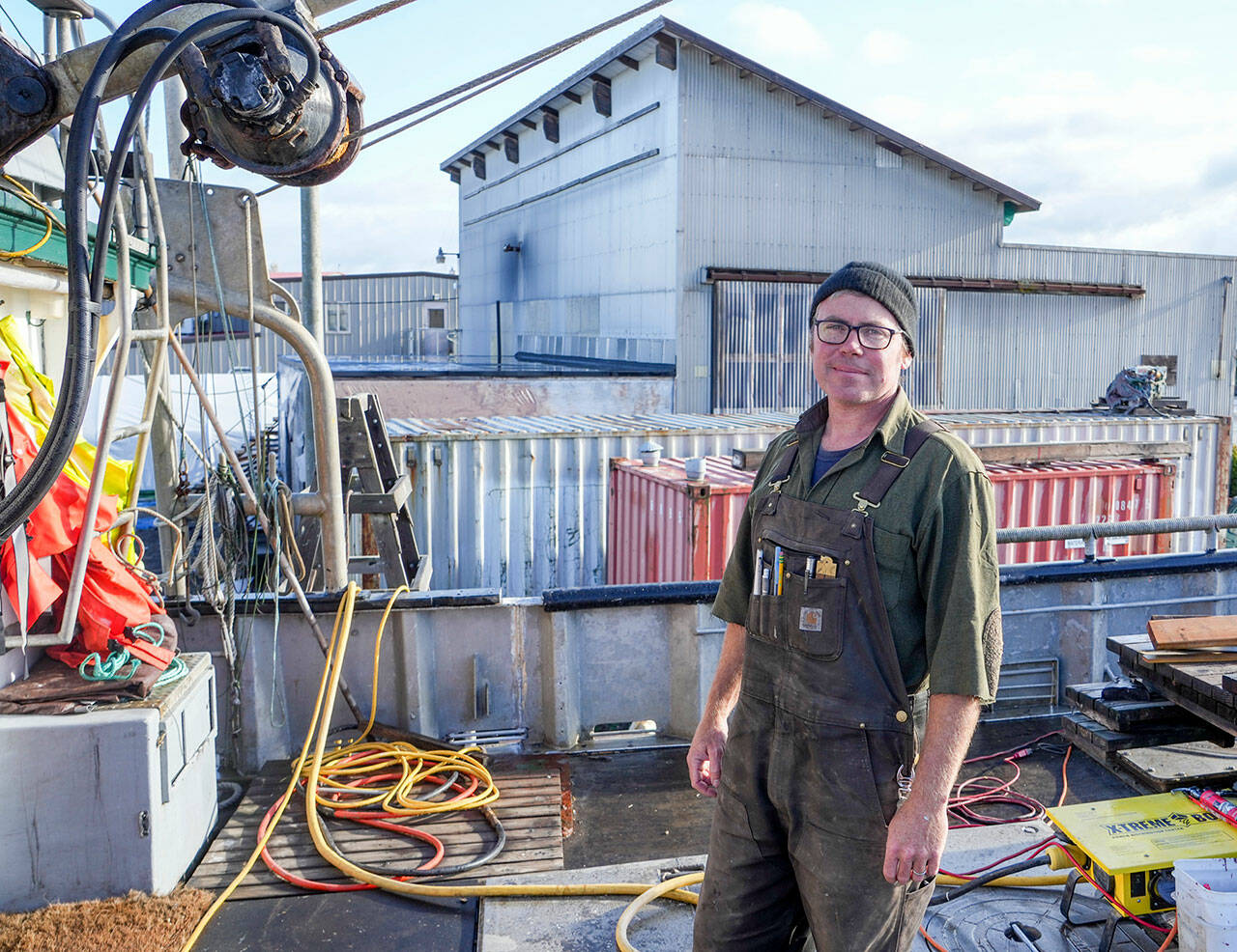 Blaise Holly, new owner of Haven Boatworks at the Boat Haven in Port Townsend, is on board the Molly, a commercial boat his company is servicing. In the background is Integrated Marine Systems, a building to which Holly will be re-locating soon. (Steve Mullensky/for Peninsula Daily News)